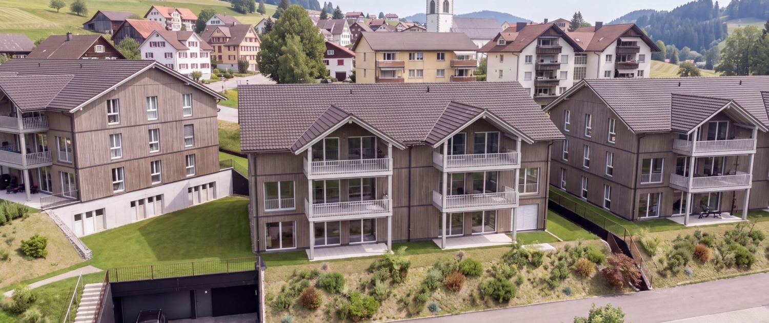 Visualisierung Haus 2 der Überbauung Kalkofen in Oberegg, im Hintergrund das Dorf mit Kirche