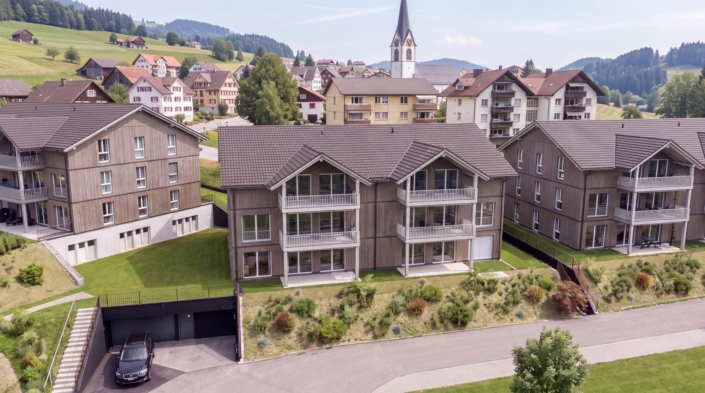 Visualisierung Haus 2 der Überbauung Kalkofen in Oberegg, im Hintergrund das Dorf mit Kirche